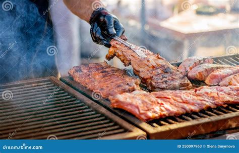 Barbecue Ribs Man In Gloves Flips Grilled Ribs On A Charcoal Grill