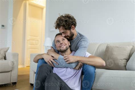 Loving Same Sex Male Gay Couple Lying On Sofa At Home And Relaxing