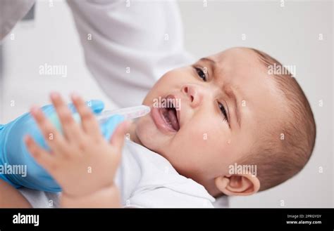 Dont Cry Little One A Doctor Giving Medicine To A Baby In A Hospital