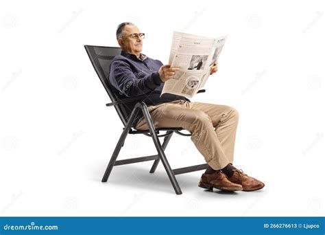 Casual Mature Man Sitting In A Foldable Chair And Reading A Newspaper Stock Image Image Of