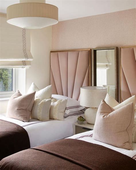 two beds in a bedroom with pink headboards and pillows on top of each bed