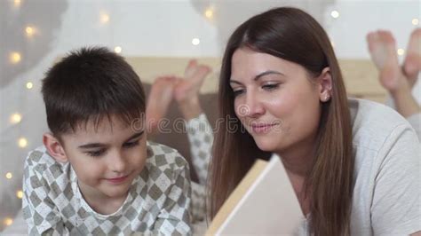 Une Belle Fille Avec De Longs Cheveux Lit Un Livre à Un Petit Garçon Se