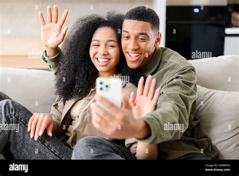 Front View Of Happy Cheerful Young Multiracial Couple Having Online Webcam Chat With Via Video