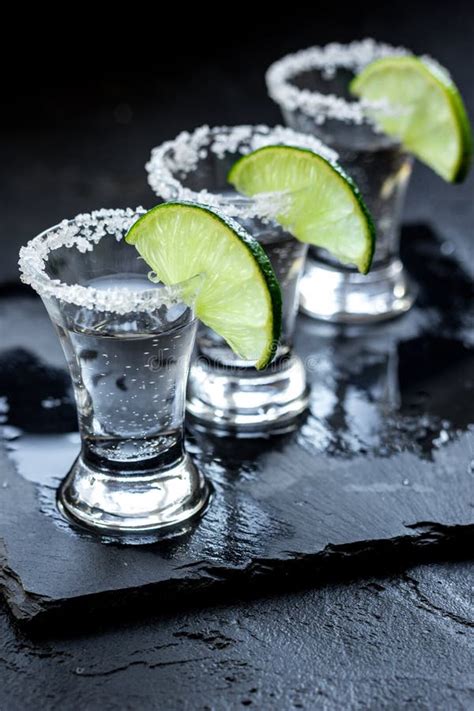 Silver Tequila Shots With Ice And Lime On Black Table Background Stock ...