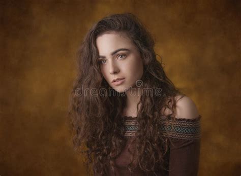 Dramatic Portrait Of A Young Beautiful Brunette Girl With Long Curly