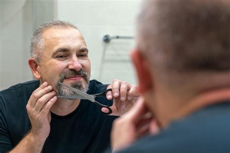 Premium Photo Portrait Of Middleaged Handsome Man Cutting His Beard