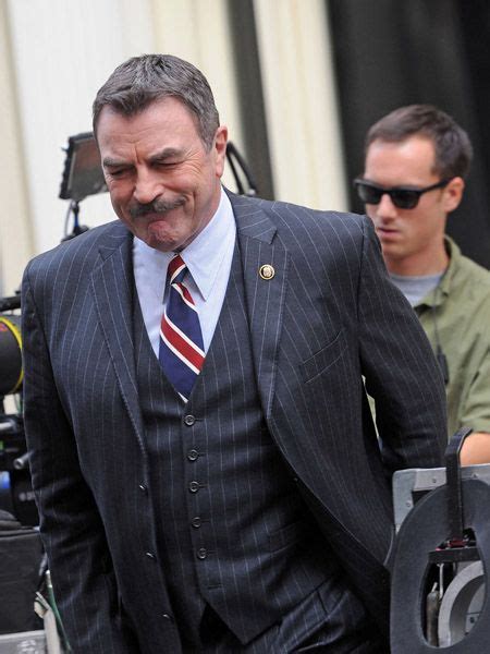 a man in a suit and tie walking down the street with another man behind him