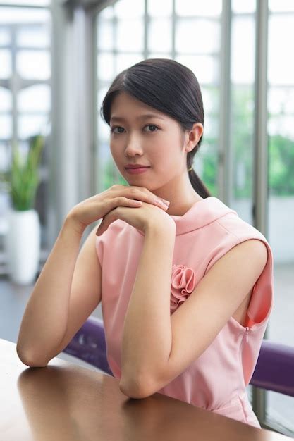 Free Photo Thoughtful Asian Woman Sitting At Table In Cafe