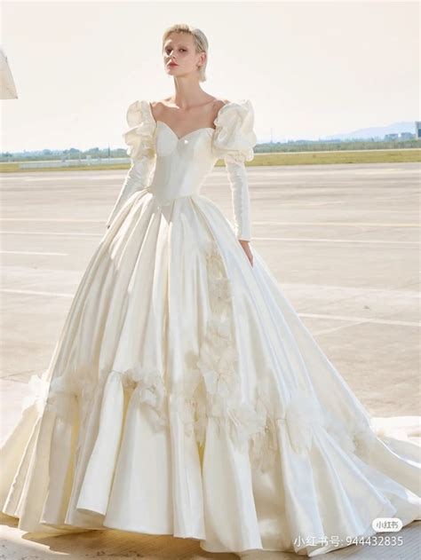 A Woman In A White Wedding Dress Standing On An Airport Tarmac