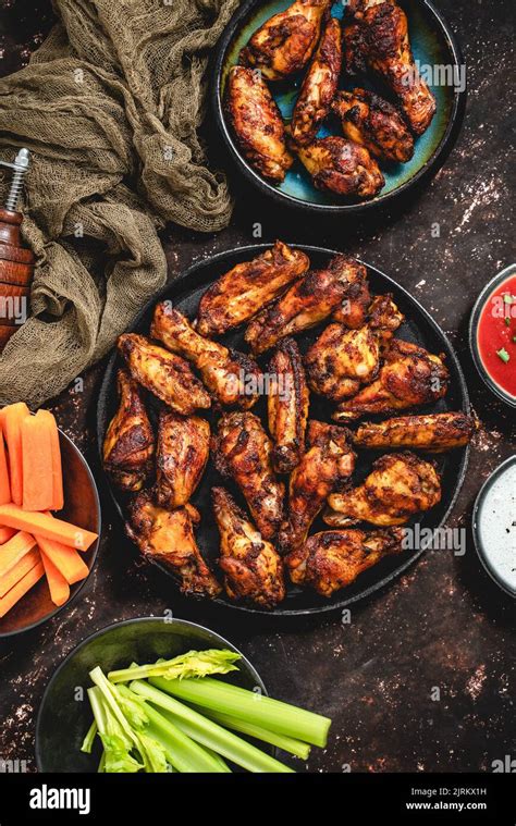 Grilled Spicy Chicken Wings Served With Tomato And Yogurt Dips Celery