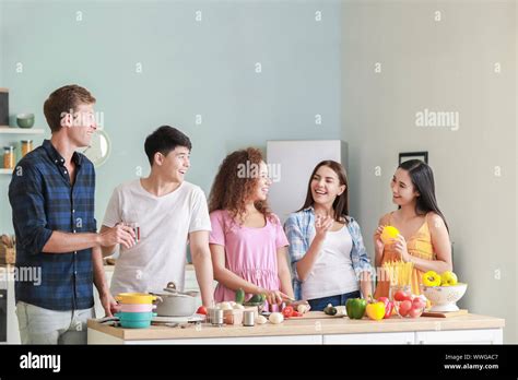 Happy Friends Cooking Together In Kitchen Stock Photo Alamy