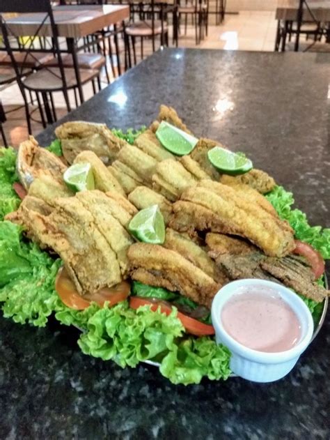 A Plate Full Of Fried Fish And Lettuce With Dipping Sauce