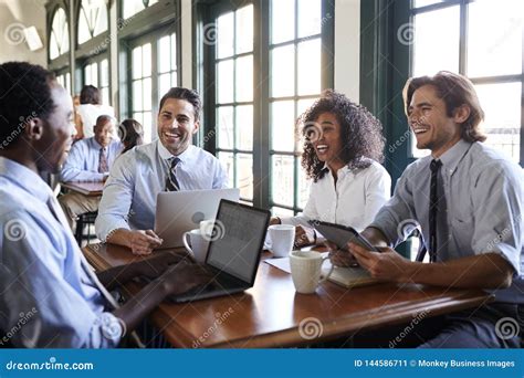 Business Team Having Informal Meeting Around Table In Coffee Shop Stock