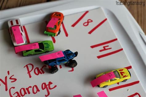 small toy cars are lined up on a white board with pink and green marker ...