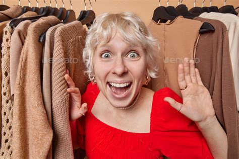Positive Blonde European Woman Stares At Something With Impressed Expression Has Widely Opened