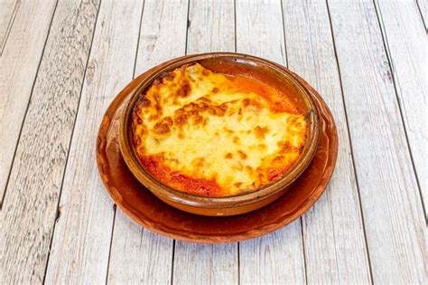 Lasa A De Carne Con Bechamel Gratinada En Cazuela De Barro Y Plato De