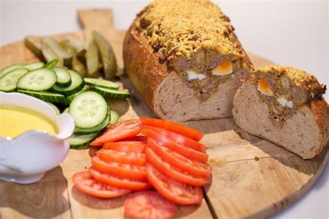 A Wooden Cutting Board Topped With Sliced Bread And Veggies