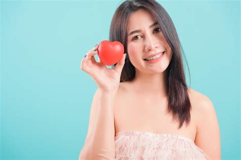 Retrato feliz asiático de mulher jovem e bonita em pé segurando um