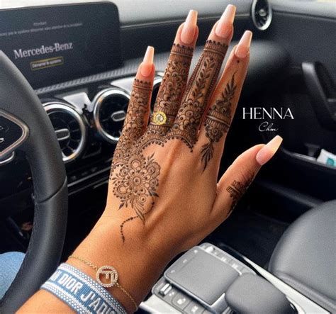 Henna On The Hand Of A Woman Driving A Car With Her Hands Resting On