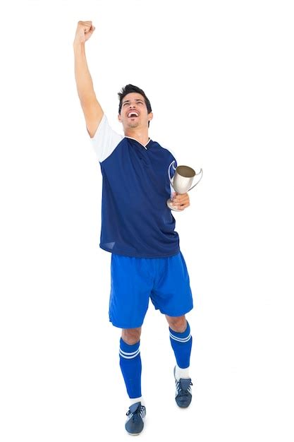 Premium Photo Football Player In Blue Holding Winners Cup