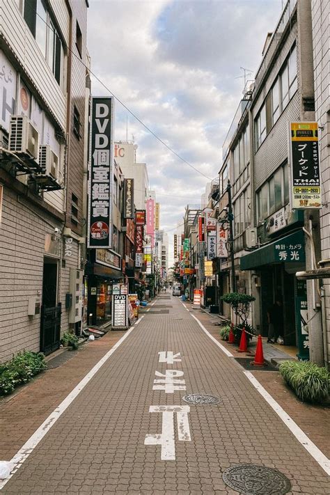 An Empty Street With Buildings And Signs On Both Sides