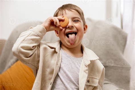 Portrait of little adorable boy holding biscuit. Kid with cookie. Child