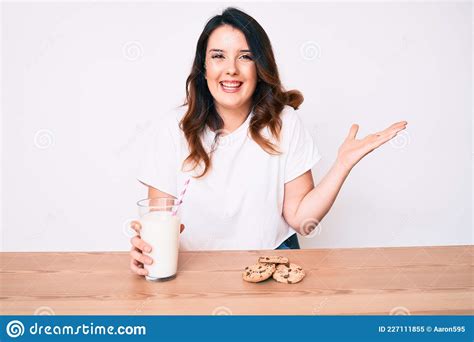 Young Beautiful Brunette Woman Drinking A Glass Of Fresh Milk With