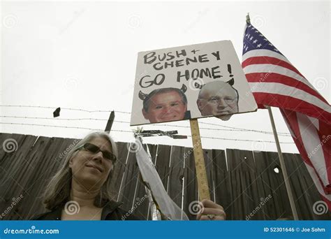 A Sign Shows President Bush and VP Cheney As the Devil with the US Flag ...