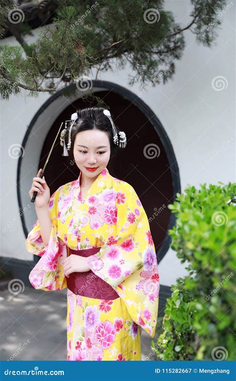 Traditional Asian Japanese Woman Bride Geisha Wearing Kimono Play In A Graden Hold A Fan Stock