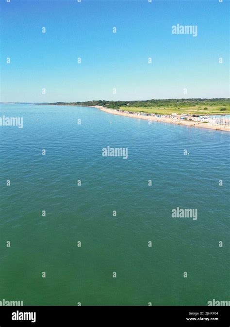 An Aerial View Of The Seascape And The Beach With A Green Space On The