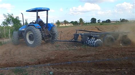 trator new Holland passando a grade aradora no sítio mata velha para o