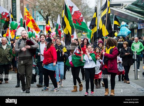 People Waving Welsh National Flags And Banners Marching Through The