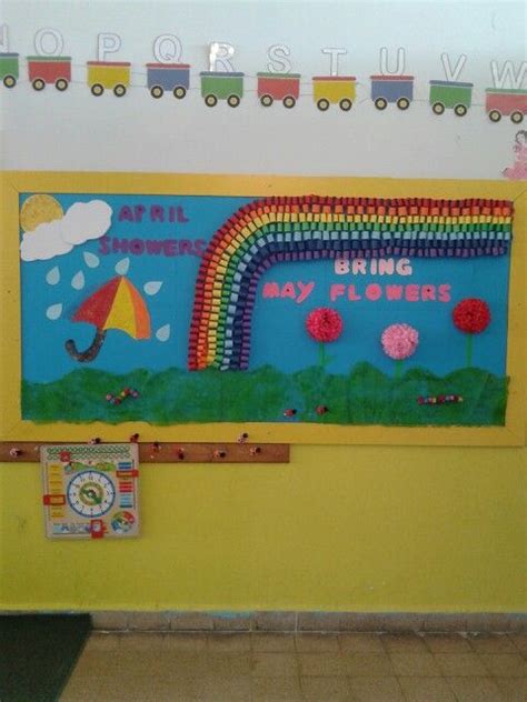 A Bulletin Board Is Decorated With Colorful Paper Flowers And A Rainbow