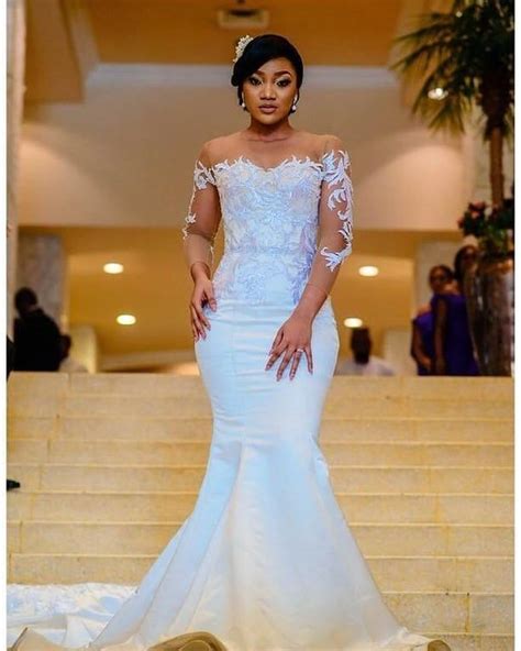 A Woman In A Wedding Dress Standing On Some Steps