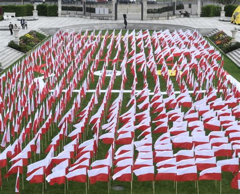 Instalacja biało czerwonych flag przed Zamkiem Królewskim w Warszawie z