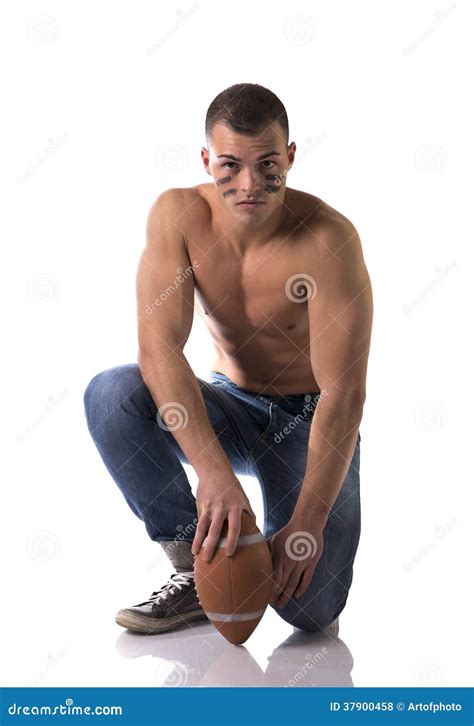 Shirtless American Football Player In Jeans With Ball Kneeling Stock