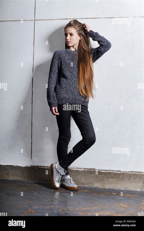 Fashion Teenager Girl Standing Leaning Back Against A White Concrete