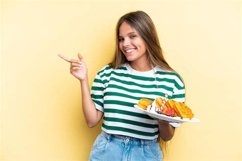 Jovem Mulher Caucasiana Segurando Waffles Isolados Em Fundo Amarelo