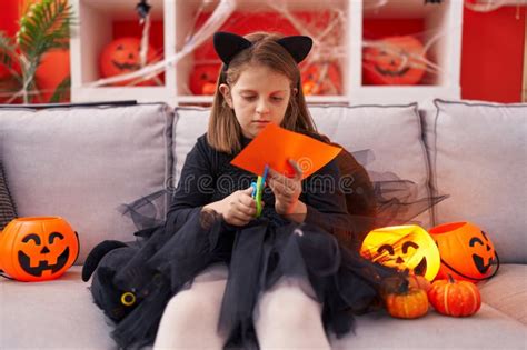 Adorable Blonde Girl Wearing Halloween Costume Cutting Paper At Home Stock Photo Image Of