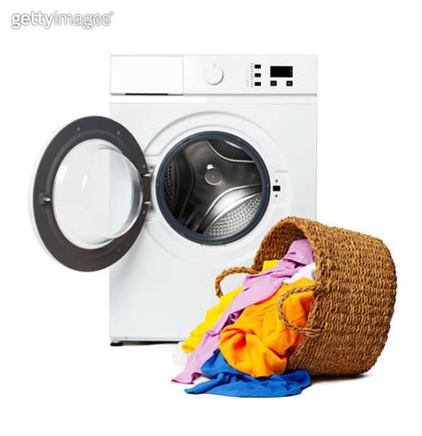 White Washing Machine With Open Door And Clothes Overflowing From A