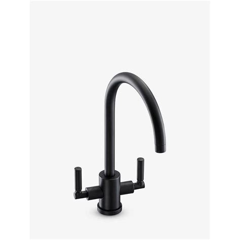 A Black Faucet With Two Handles And Nozzles On The Side In Front Of A