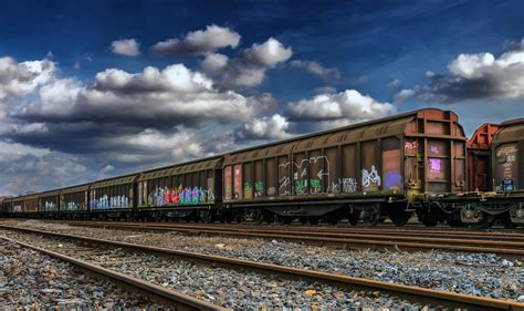 Red Train on Tracks With Green Grass Beside Under Bright Sky · Free
