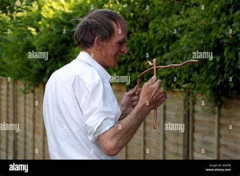 Water Divining Man Using Copper Divining Rods To Trace Water Flow