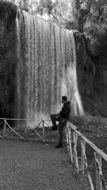 Premium Photo Full Length Of Man Leaning On Railing Against Waterfall