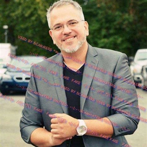 A Man Standing In Front Of A Parking Lot With His Arms Crossed