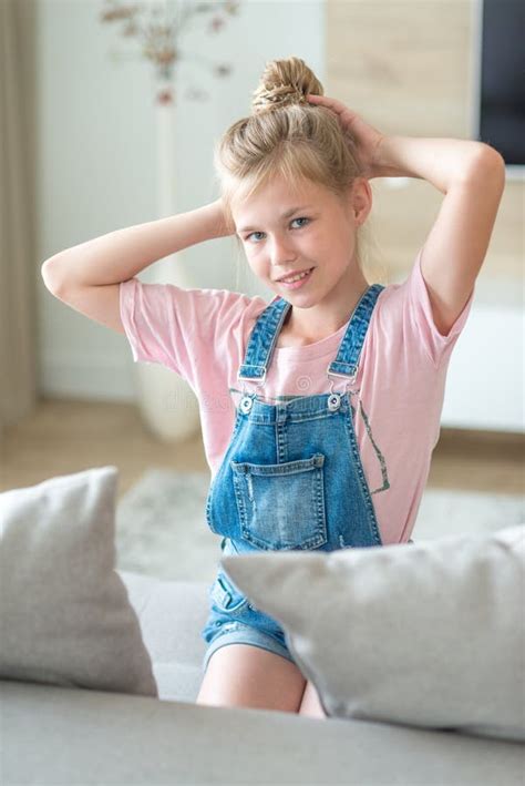 Portrait De La Fille Pré adolescente Blonde S asseyant Sur Le Divan