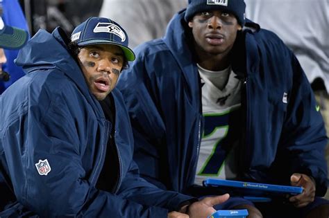 Seahawks QB Russell Wilson helps Geno Smith while nursing finger injury