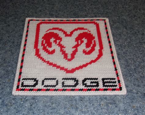 A Red And White Knitted Rug With The Word Dodge Written In Black On It