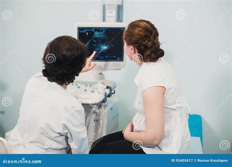 Doctor Showing Baby Ultrasound Image On Computer To Pregnant Woman