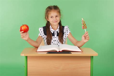 Fille Dans Luniforme Scolaire Se Tenant Sur Une Chaise Photo Stock